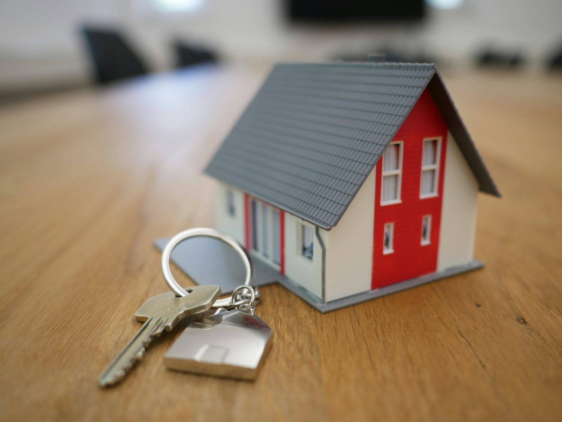 Miniatur eines weißen und roten Holzhauses auf einem braunen Tisch